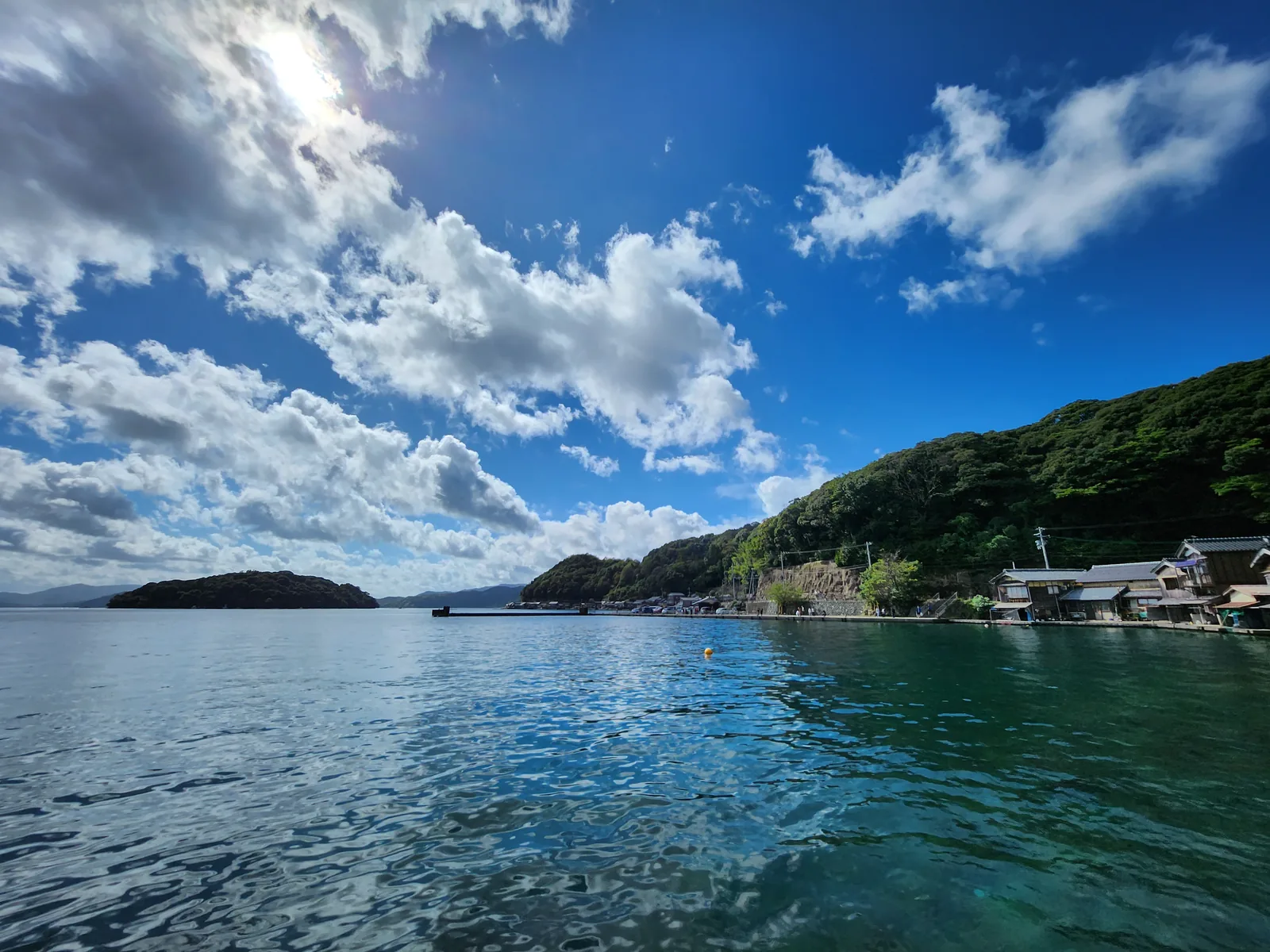 伊根灣藍色海面、島嶼與沿岸舟屋聚落全景