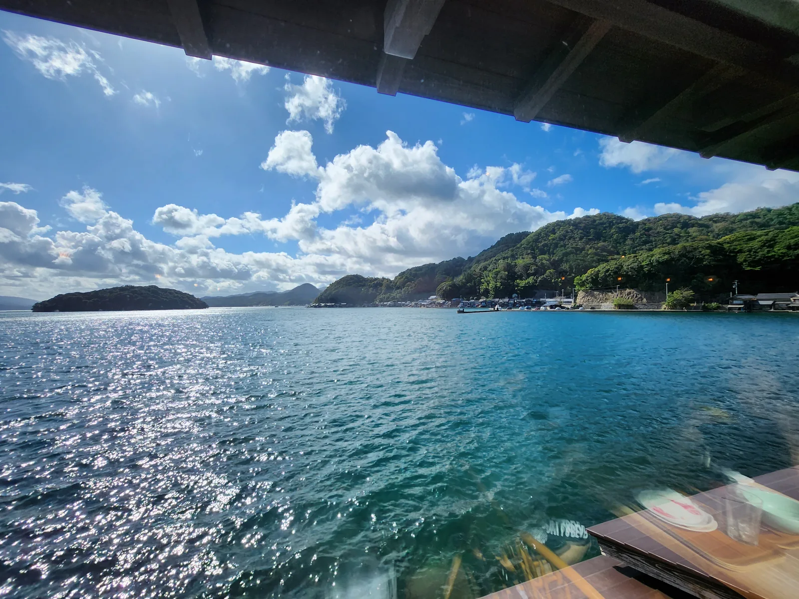 從伊根舟屋建築窗邊望向陽光下的伊根灣海景