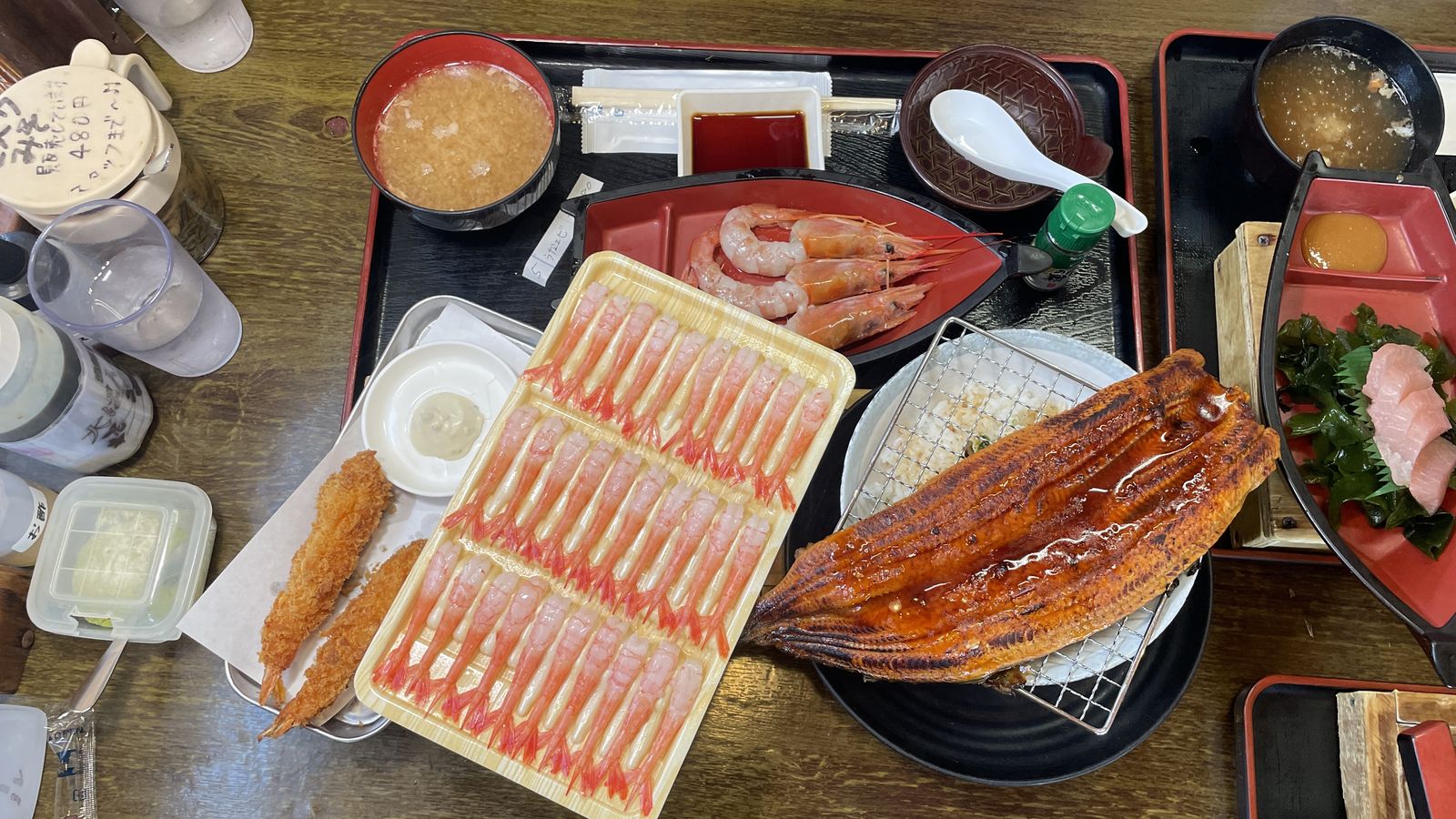 桌上擺滿的超豪邁海鮮大餐:整盒甜蝦刺身、烤鰻魚、炸蝦與生魚片船