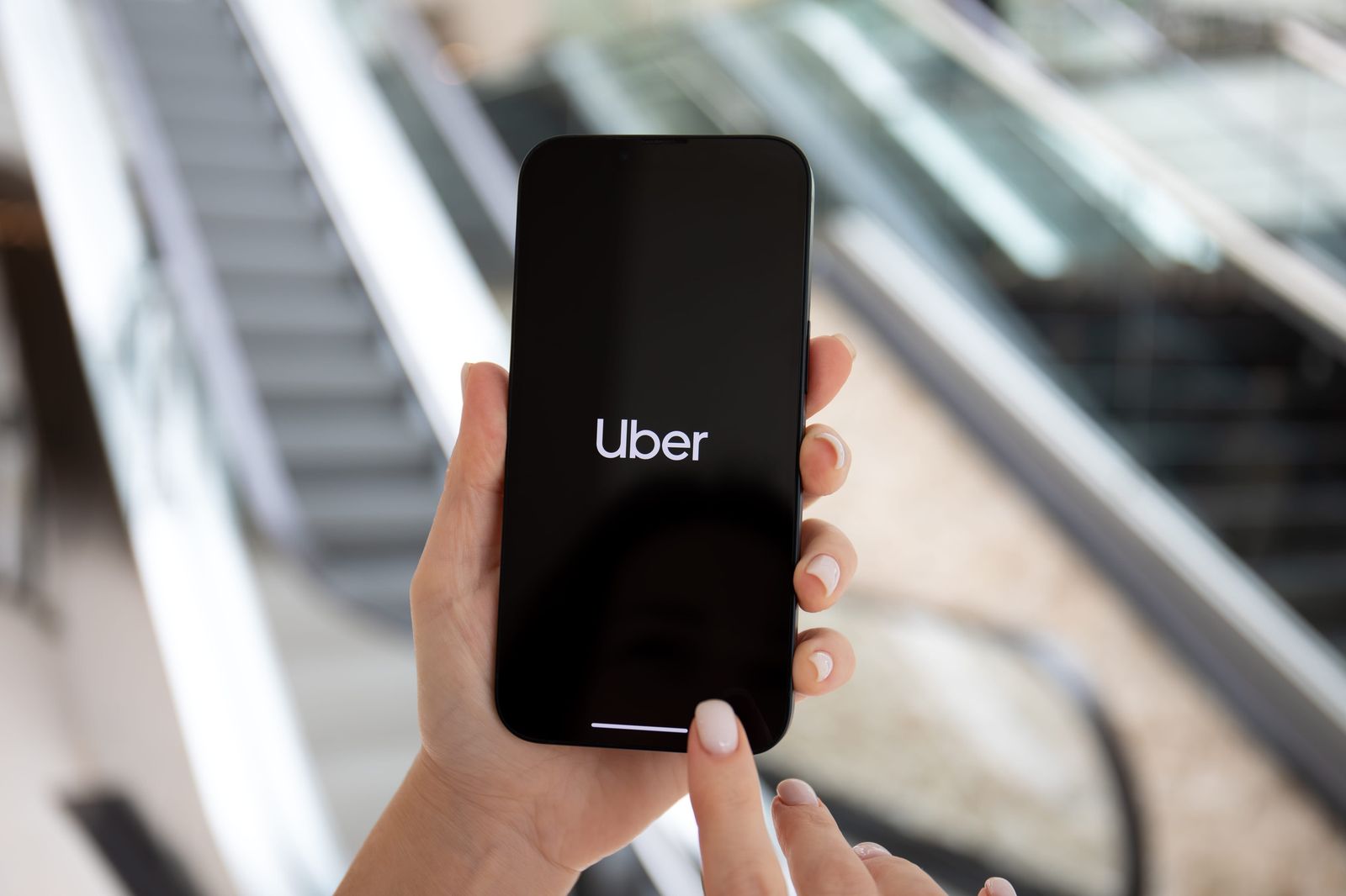 旅客以手機開啟 Uber 叫車 App