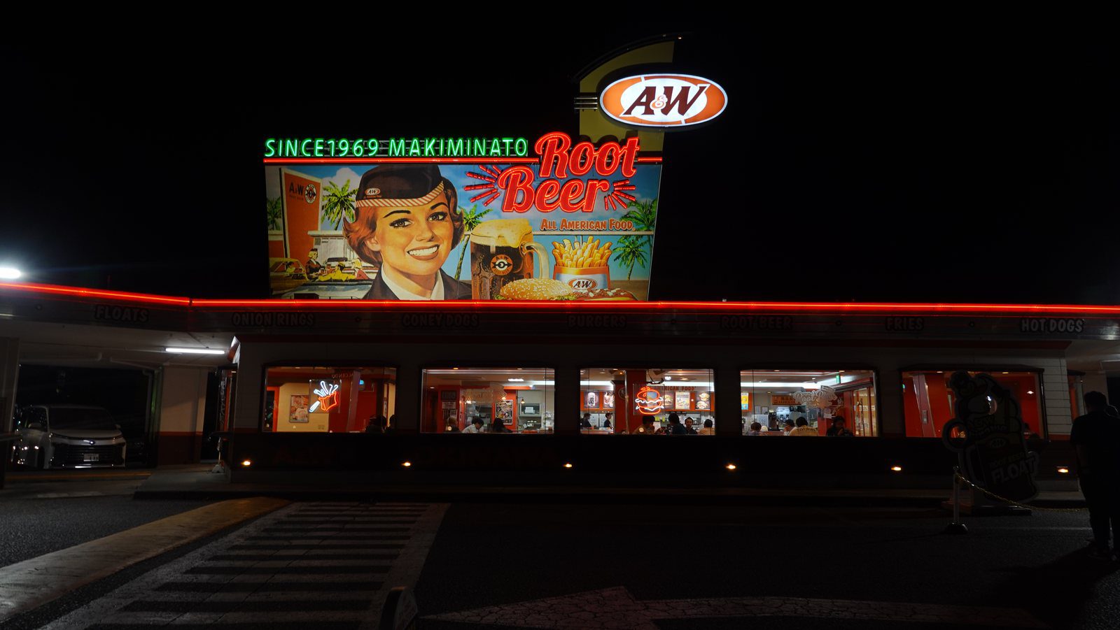 沖繩 A&W 牧港店夜間外觀，紅色燈帶上方有大型 Root Beer 復古看板