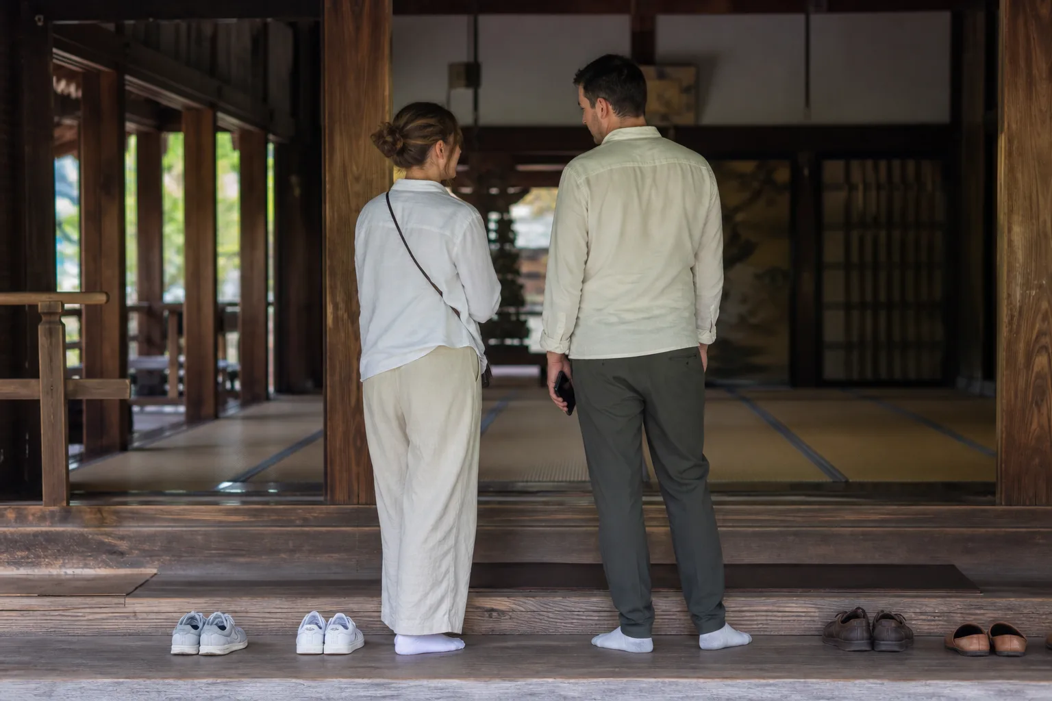 情境示意：旅客脫鞋後安靜進入日本寺院木造建築