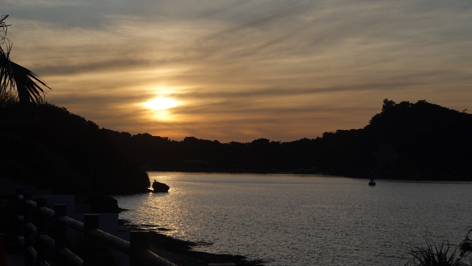 夕陽落在古宇利大橋南端海灣後方