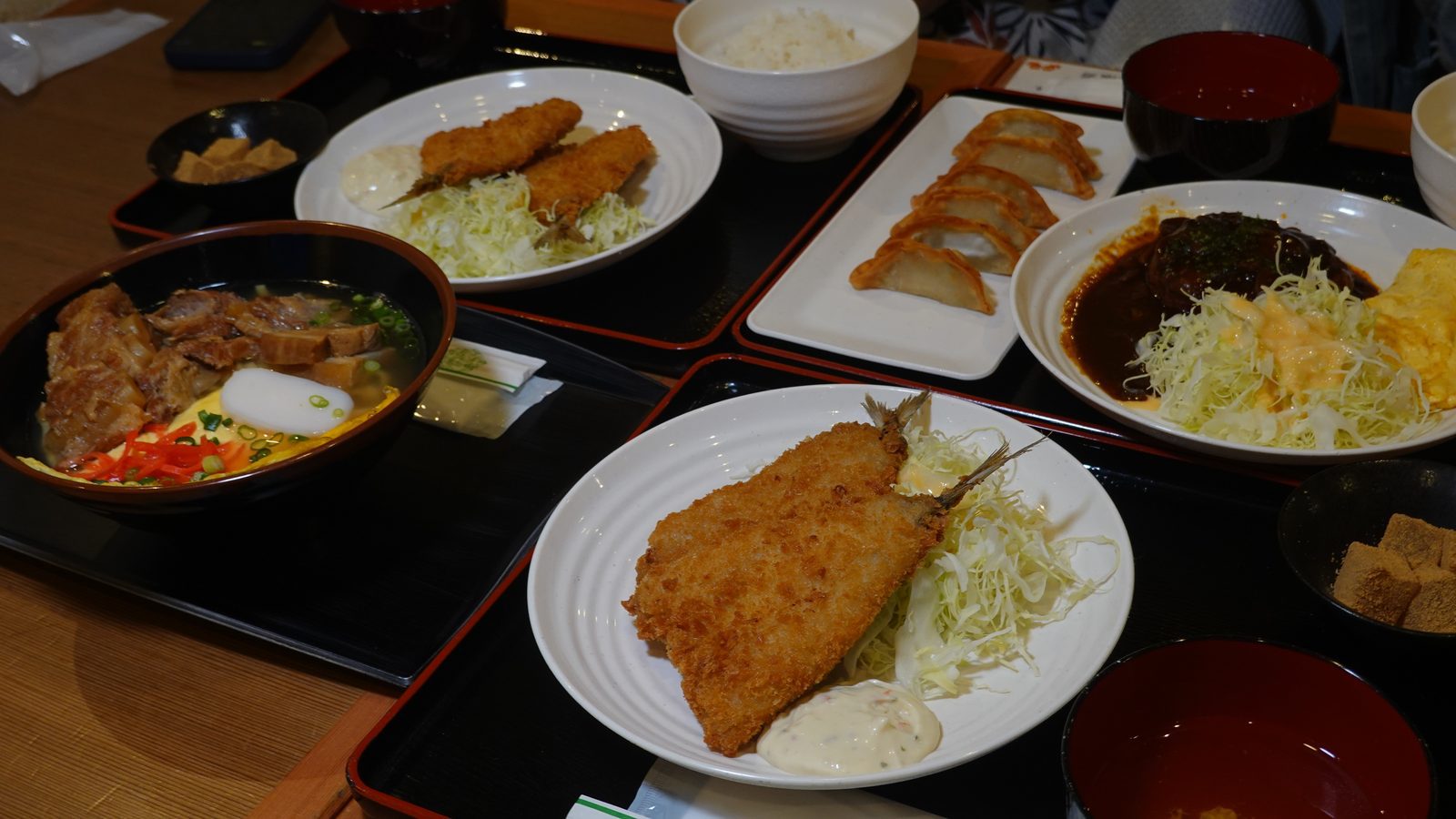 擺滿沖繩麵、炸魚定食、漢堡排與餃子的豐盛餐點全景
