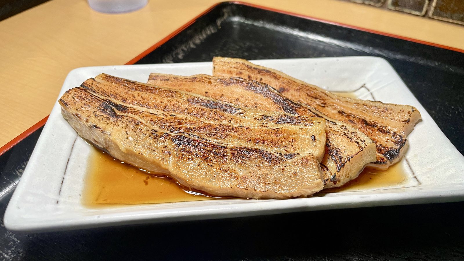 白瓷小盤上的炙燒三層肉特寫