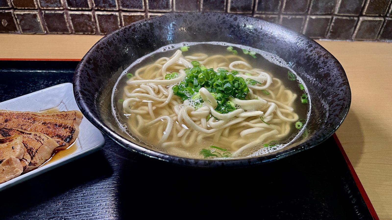 澄澈金黃的鰹魚高湯沖繩麵與鮮綠蔥花