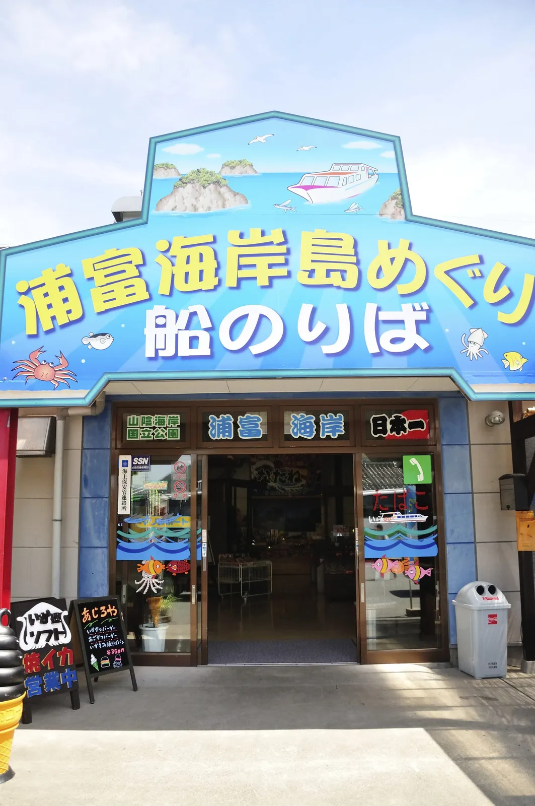 浦富海岸島嶼遊覽船乘船處入口與大型藍色招牌