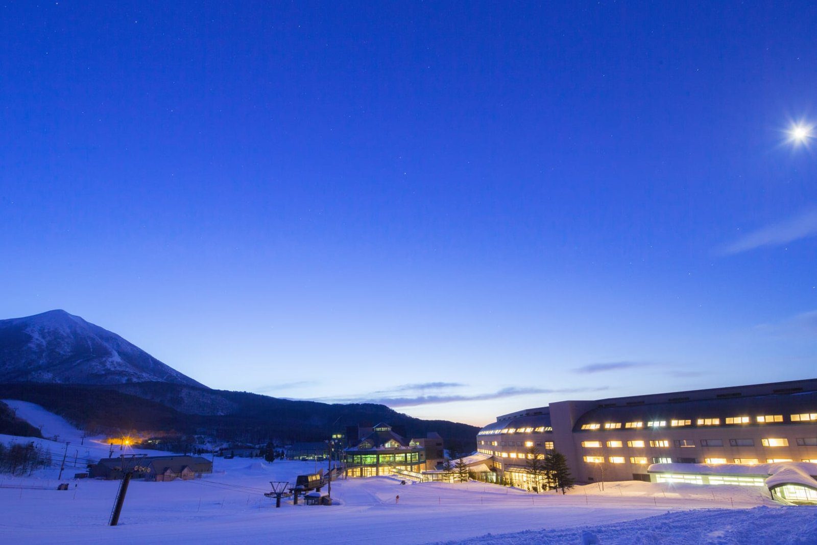 星野集團 磐梯山溫泉飯店 黃昏雪景中的飯店建築與磐梯山