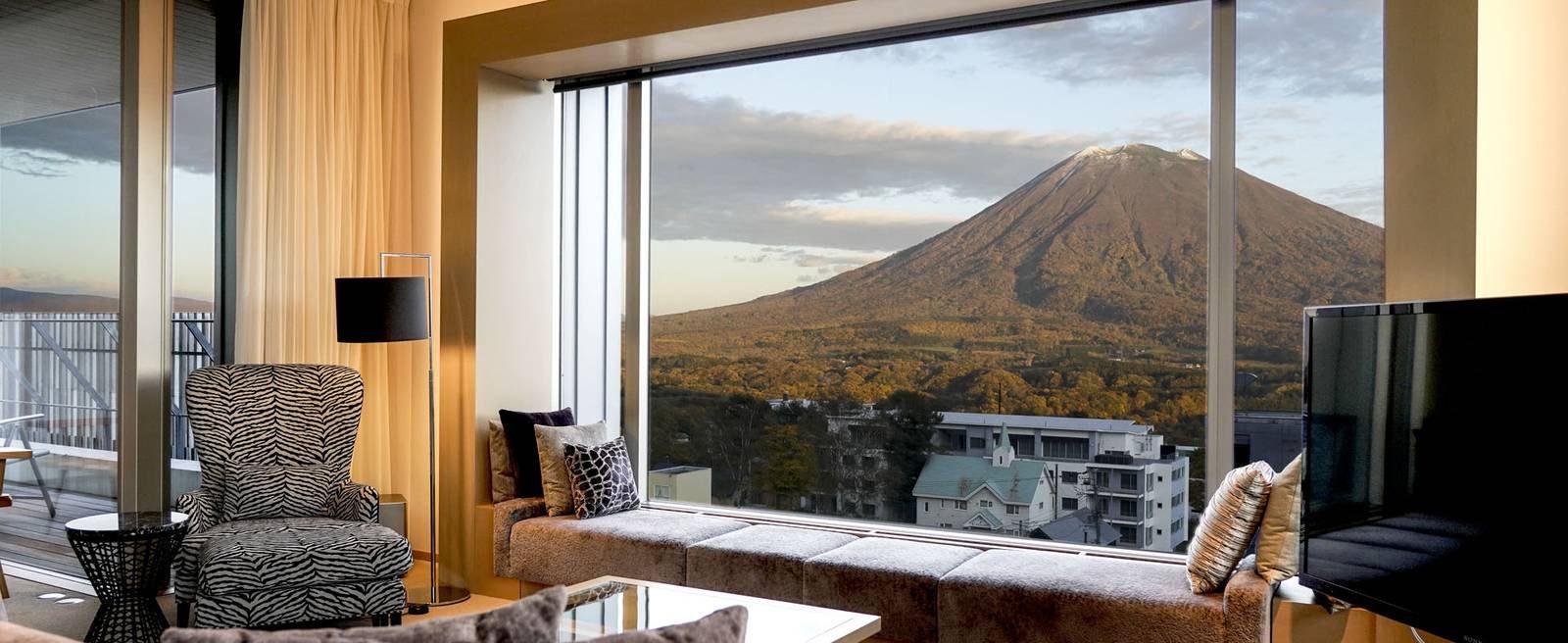二世古比羅夫夏萊艾比酒店 套房客廳落地窗外的羊蹄山與比羅夫村