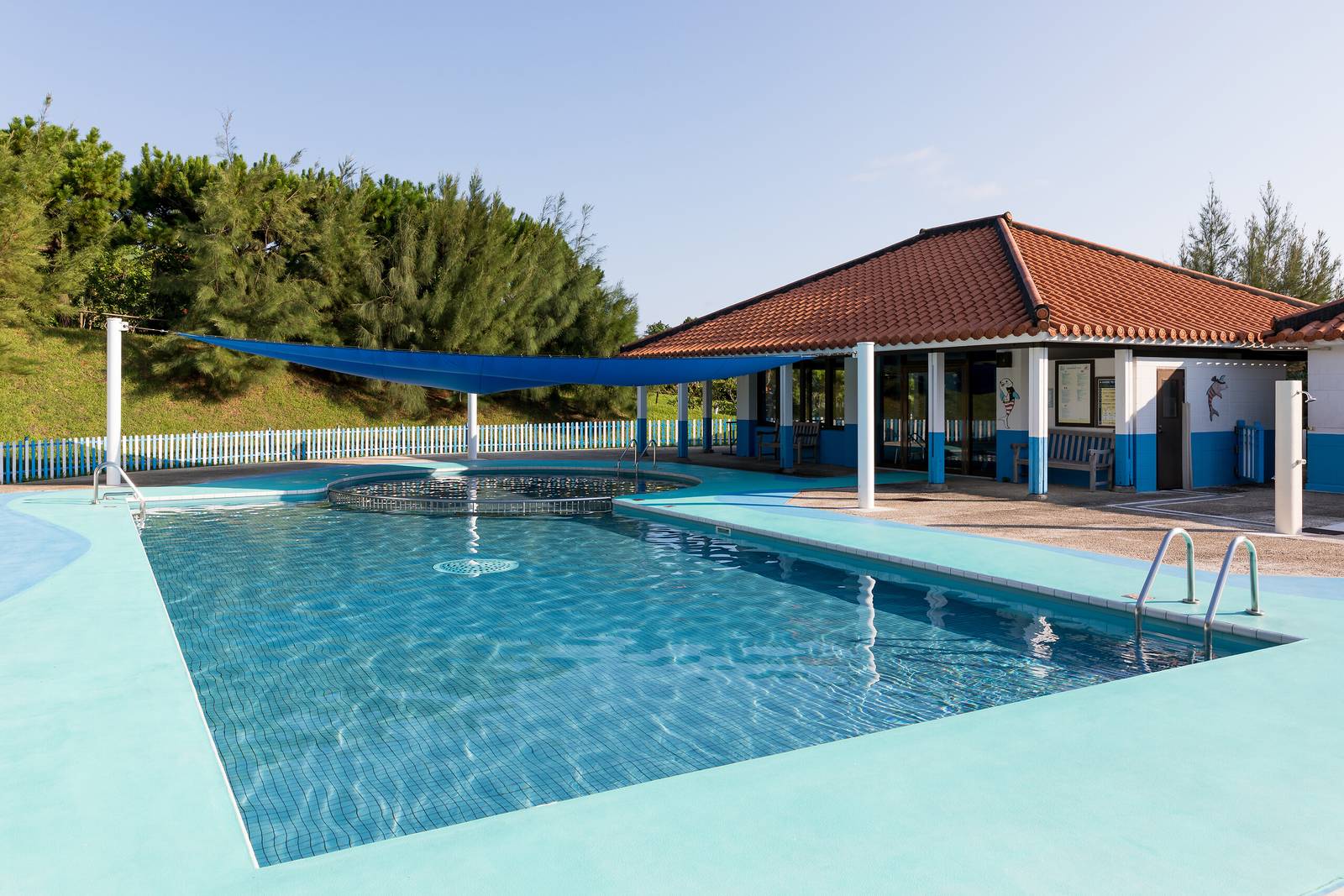 石垣島川平 Club Med 度假村｜度假村泳池與後方紅瓦屋頂的建築