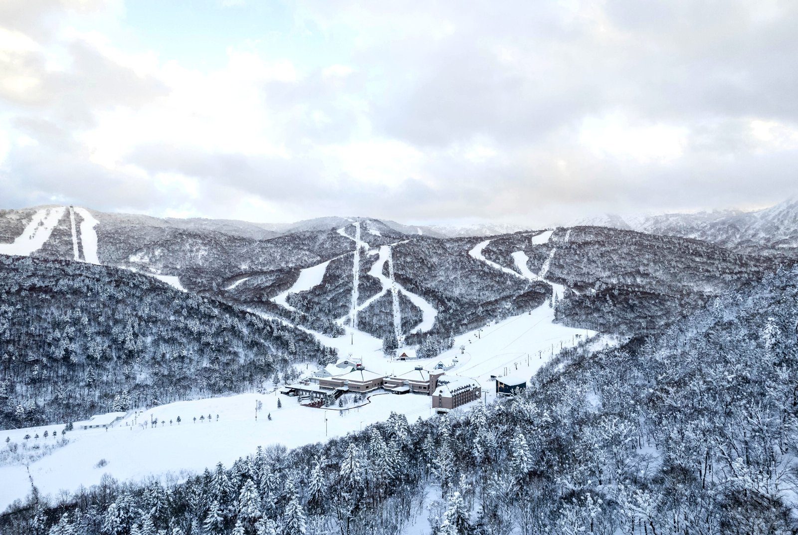 北海道喜樂樂 Peak 滑雪度假村 山谷裡的喜樂樂雪道、纜車線與度假村空拍