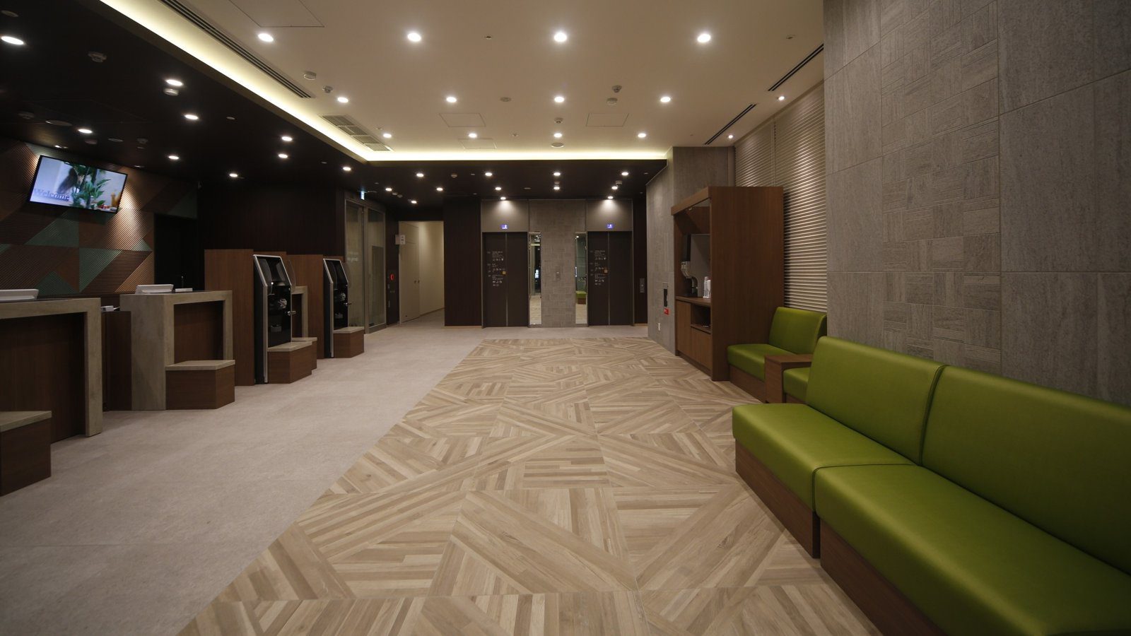 Dormy Inn 本八戶 大廳的綠色沙發與自助機台