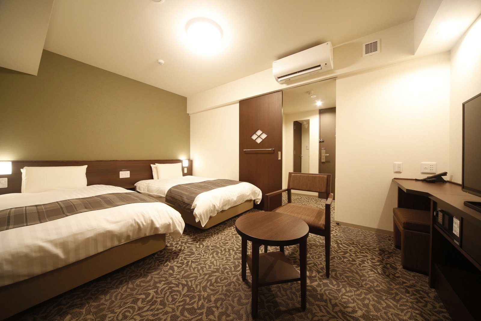 Dormy Inn 甲府丸之內 23 ㎡ 雙床房的兩張床與圓桌