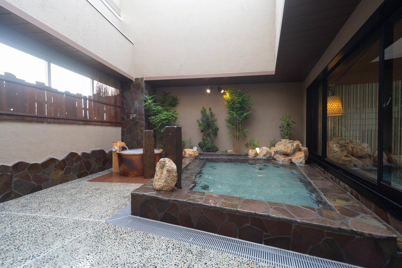 Dormy Inn 大分 12 樓露天區的浴池與岩石造景