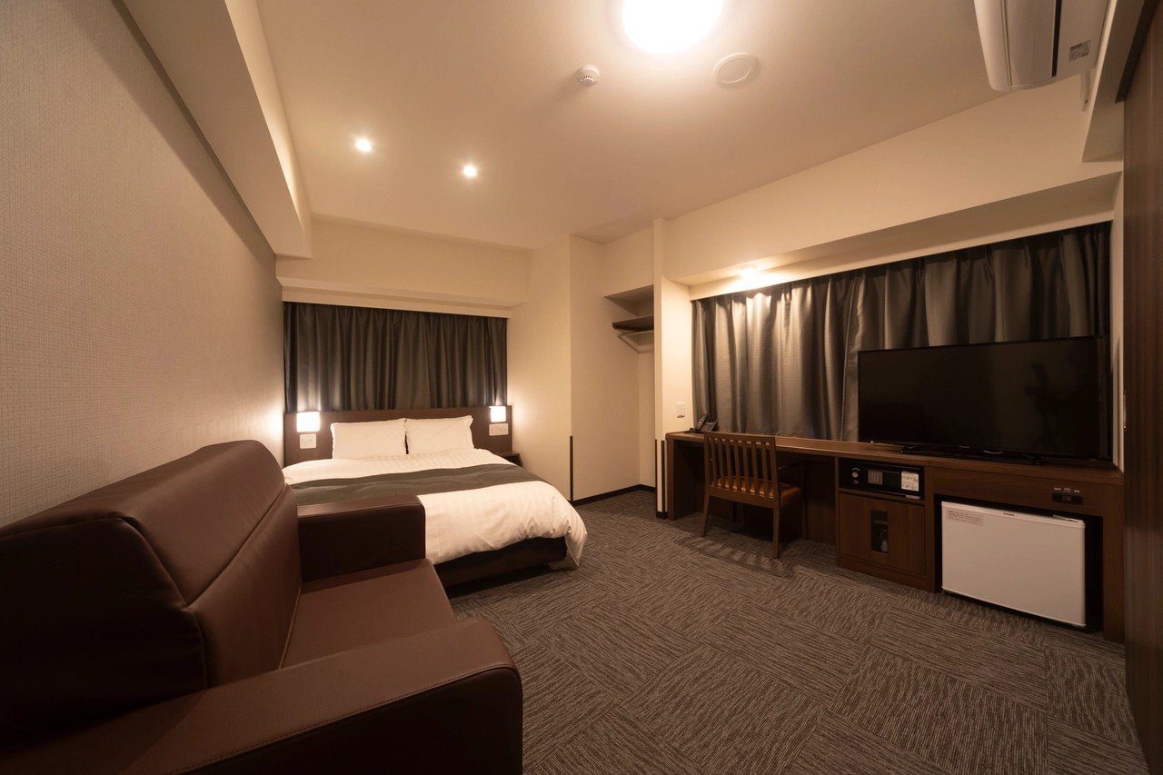 Dormy Inn 大分 放一張大床與沙發的客房