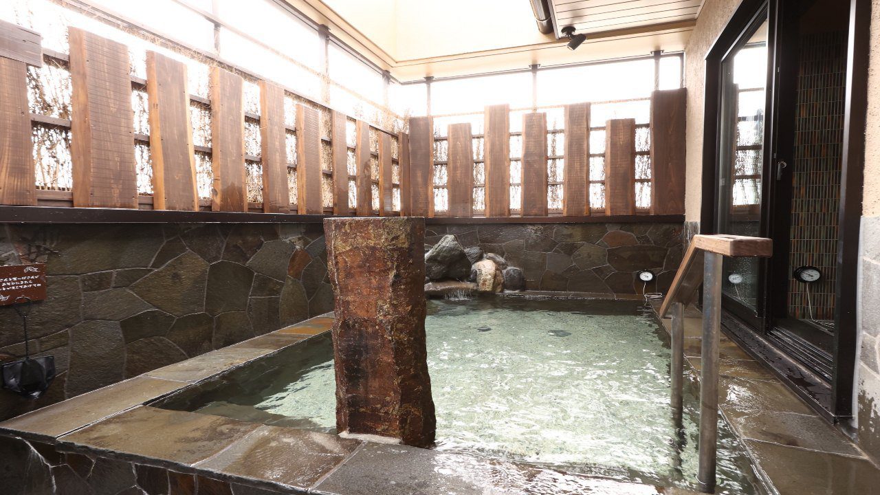 Dormy Inn 岡山 11 樓男湯的石砌露天風呂與木格柵