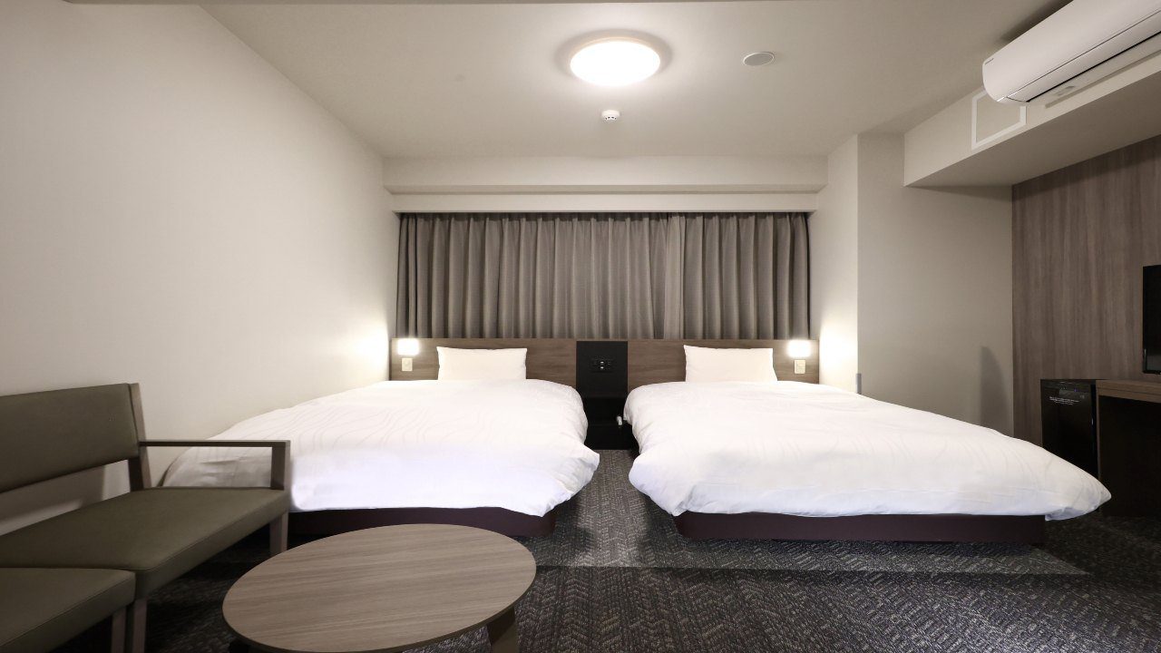 Dormy Inn 岡山 高級雙床房的兩張床與沙發