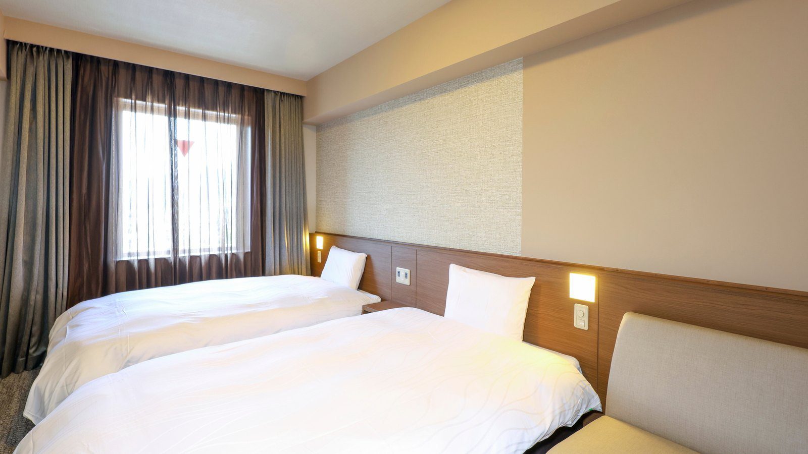 Dormy Inn 敦賀 雙床房的兩張床與窗邊沙發