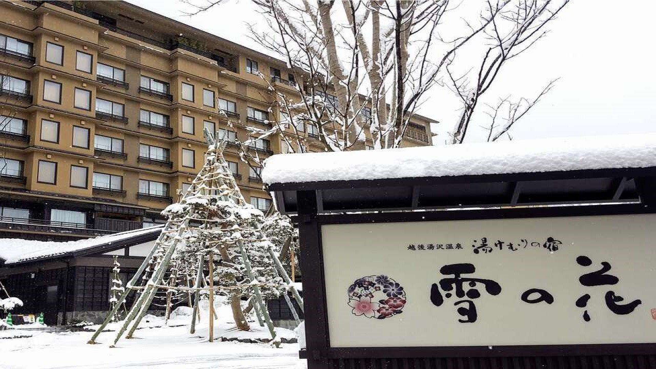 越後湯澤溫泉 湯煙之宿 雪之花 積雪中的館名招牌與旅館大樓