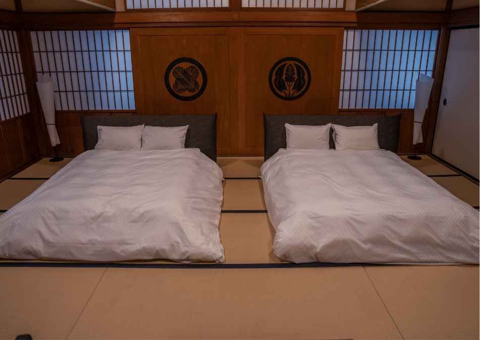 福山城 Castle Stay 月見櫓 2 樓臥室的兩張床與家紋