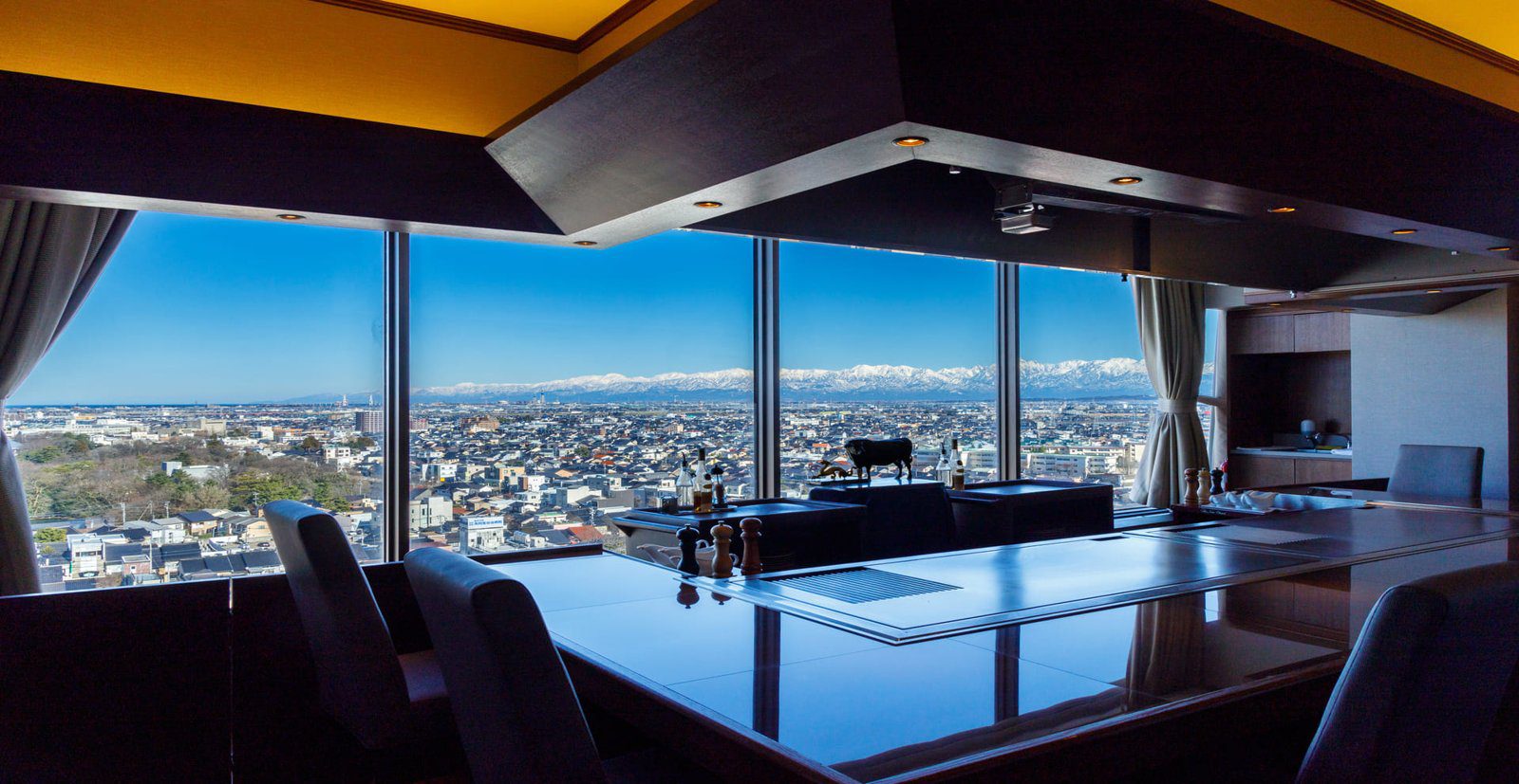 高岡新大谷飯店 鐵板燒吧檯窗外的市街與遠方雪山