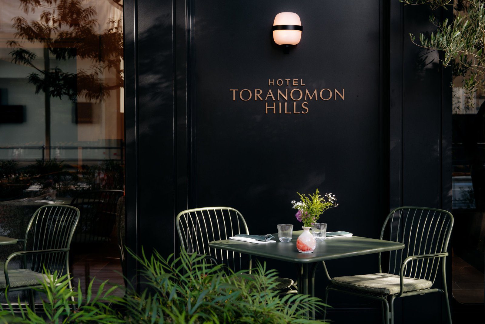 虎之門之丘酒店 1 樓外牆的 HOTEL TORANOMON HILLS 字樣與露台座位