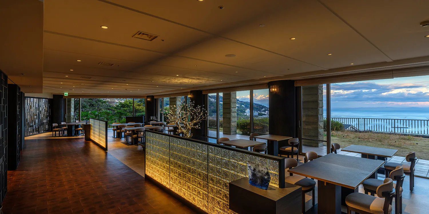 龜之井酒店 熱海 面海大窗的餐廳座位區