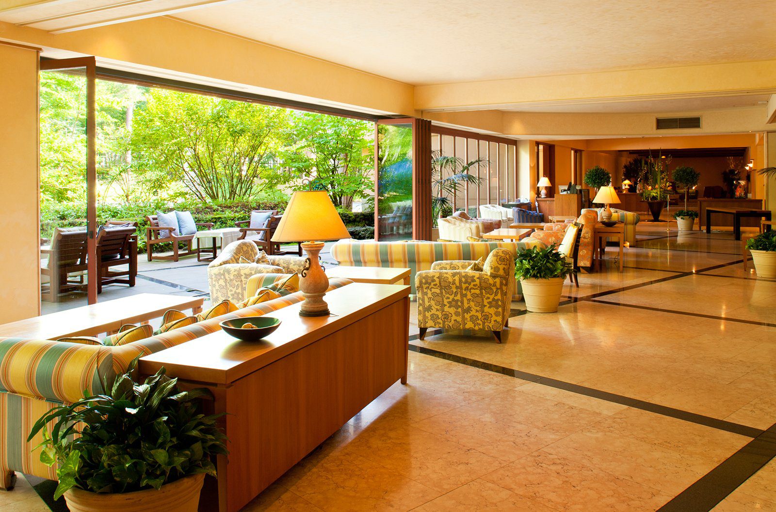 輕井澤 Hotel Bleston Court Lounge 的沙發區、檯燈、大理石地板與窗外露台