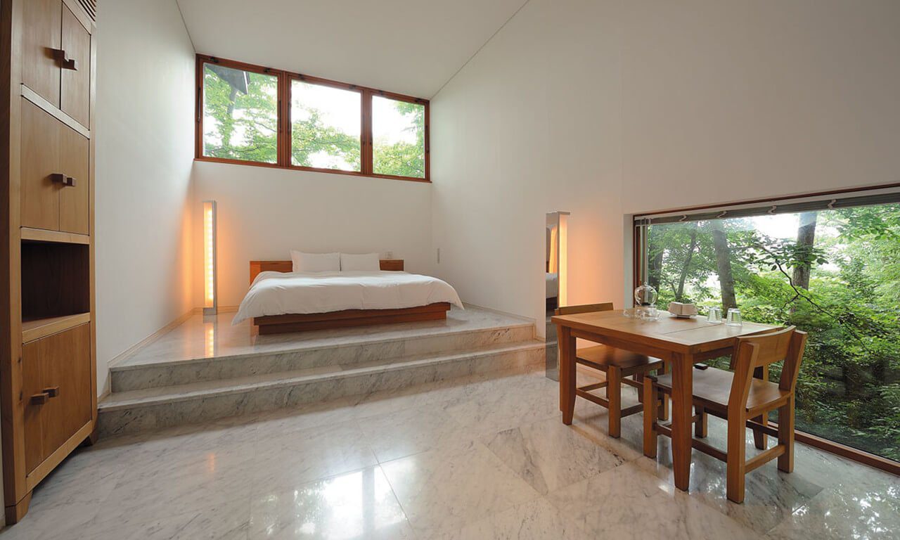 輕井澤 Hotel Bleston Court Designer's Cottage 的白牆、大理石地板、床與木桌