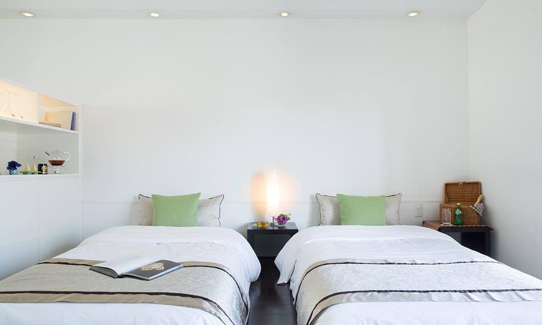 輕井澤 Hotel Bleston Court Terrace Villa 雙床房的白色床組與綠色抱枕