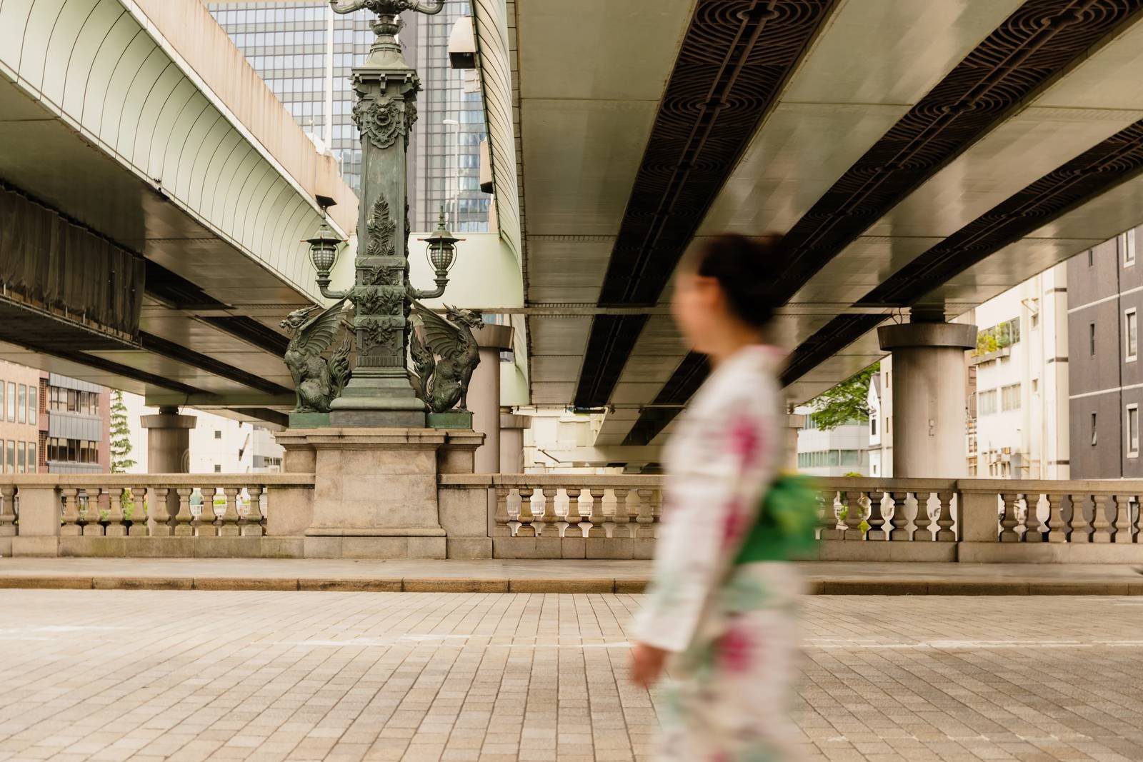 東京文華東方酒店 日本橋的石造橋欄、燈柱、上方的首都高速公路與走過的浴衣旅人