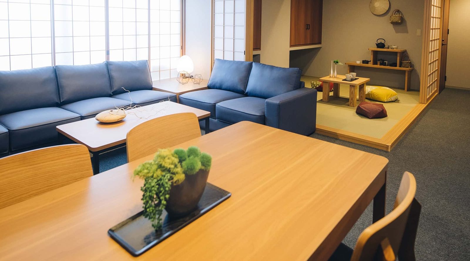 MIMARU SUITES 京都四条 藍色沙發的客廳與大餐桌