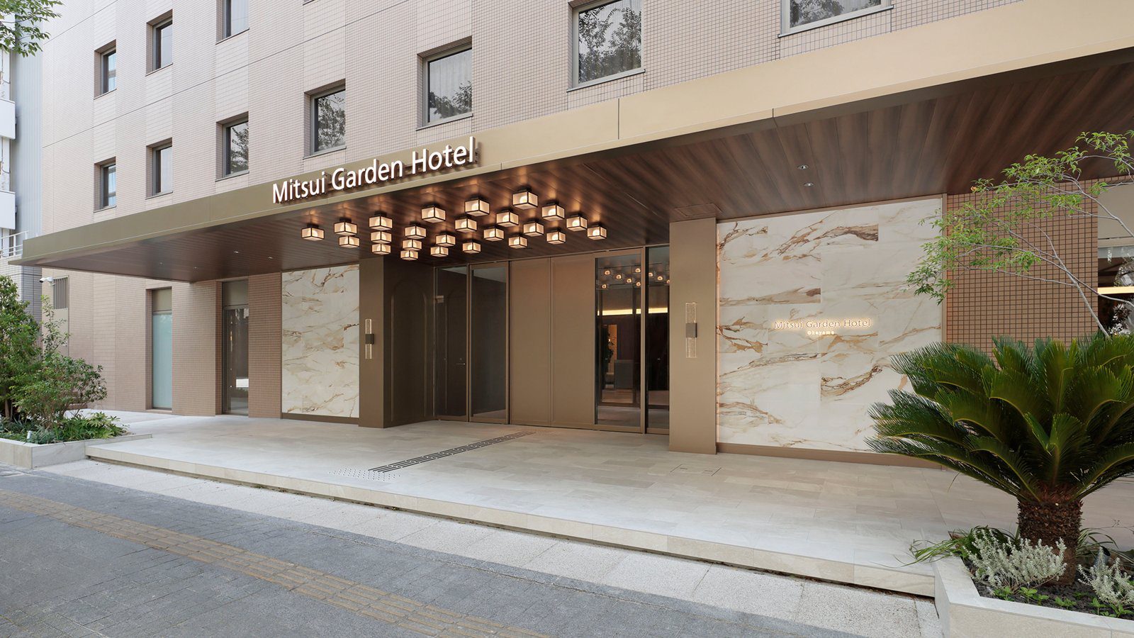 三井花園飯店 岡山 有燈飾頂棚的飯店正門與前方車道