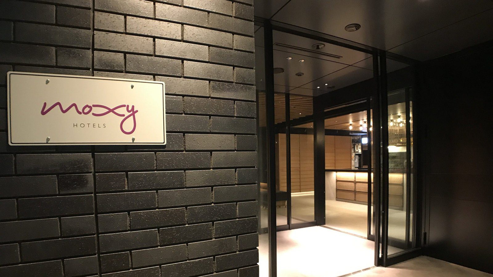京都 Moxy 酒店 磚牆上的 moxy 招牌與入口