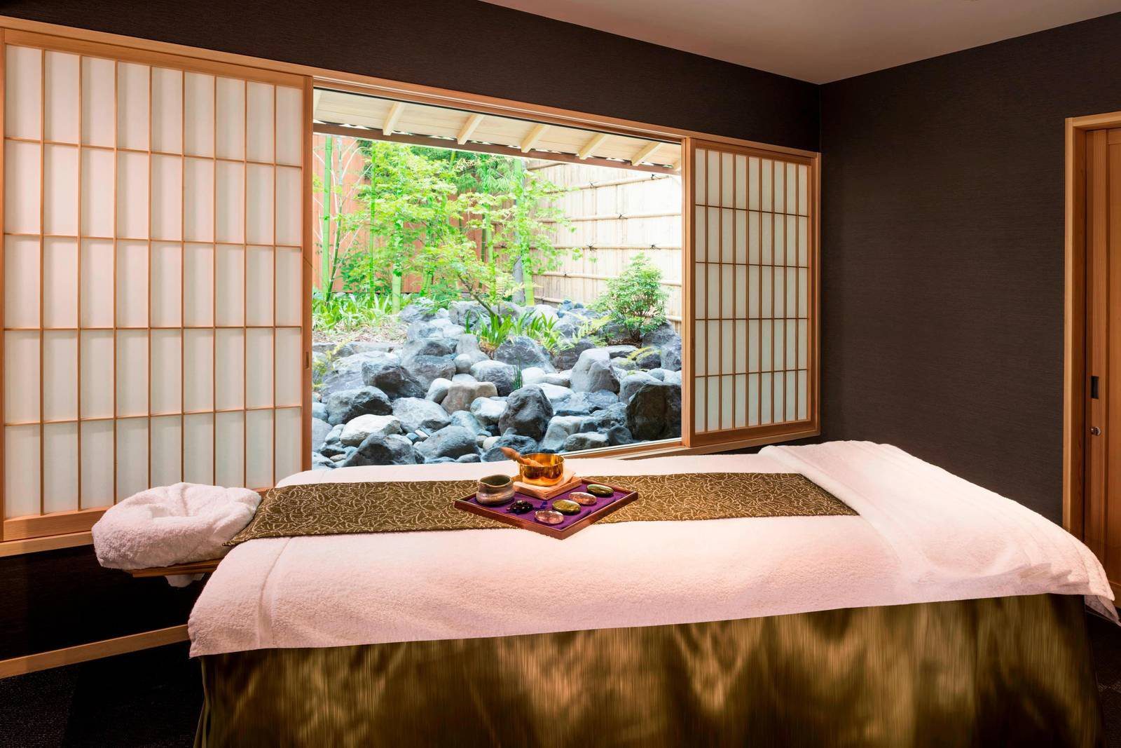 京都翠嵐豪華精選酒店 Spa 療程室的療程床與窗外石庭