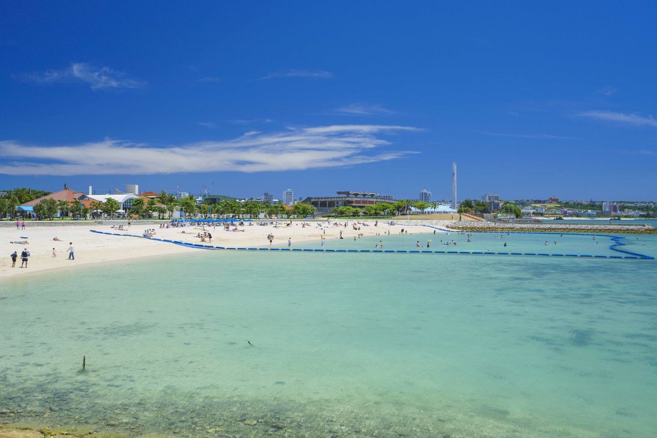 The Beach Tower 沖繩 日落海灘的淺灘與遠方的美國村
