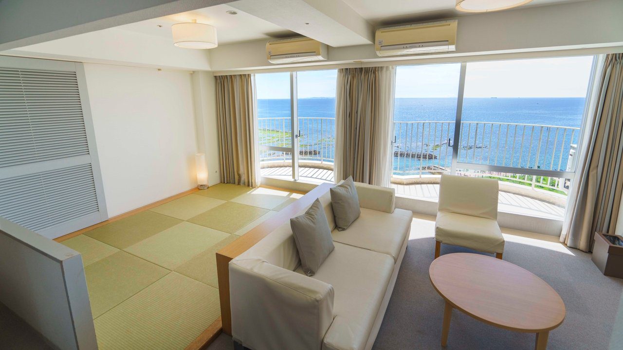 The Beach Tower 沖繩 家庭標準房的和室、沙發區與窗外海景